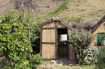 Rural wooden hut in the countryside with a garden full of plants (Madeira, Portugal, Europe)