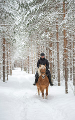 Woman horseback riding in winter