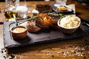Pork tenderloin served on a board in restaurant