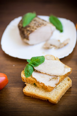 sandwich with home baked meat in a plate on a wooden
