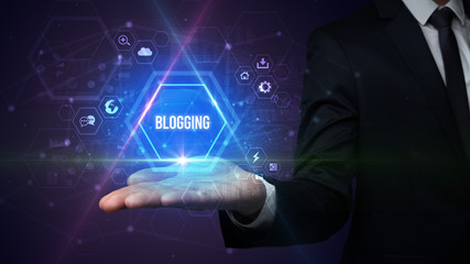 Man hand holding BLOGGING inscription, social media concept
