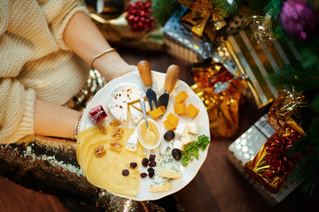 Closeup on trendy middle age woman holding cheese platter