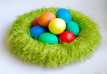 easter composition with colorful eggs laying in green wreath
