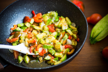 fried zucchini with red pepper, onions, tomatoes and other vegetables