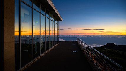 glass building on the top of the mountain at sunset