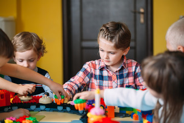 Educational toys for preschool and kindergarten child. Child playing with constructor blocks at class.