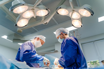 Hospital - surgery team in the modern operating room or operating theatre in a clinic operating a...