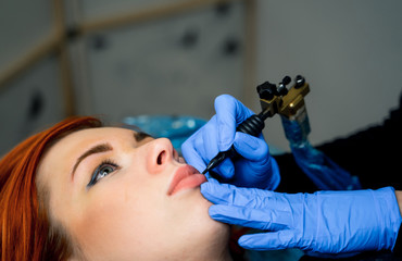 Cosmetologist making permanent makeup on woman's face, cropped photo. Beauty concept. Closeup