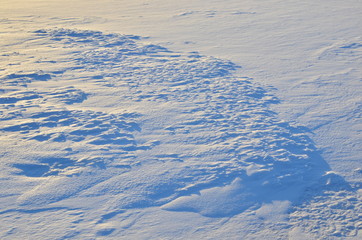 Close up of white snow background. Snow covered ground on a frosty winter day. The concept of colds and blizzards. Frozen river or lake, pure tone texture