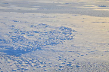 Close up of white snow background. Snow covered ground on a frosty winter day. The concept of colds and blizzards. Frozen river or lake, pure tone texture