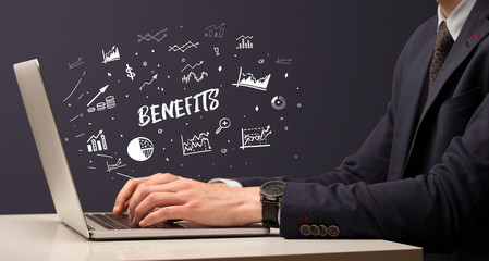 Businessman working on laptop with BENEFITS inscription, modern business concept