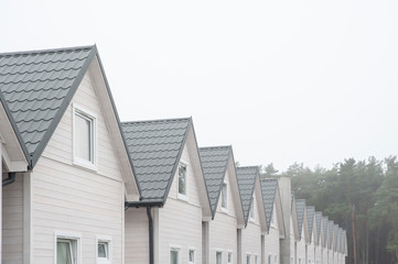 Row of wooden holiday houses on a foggy day