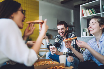 Excited friends enjoying tasty pizza together