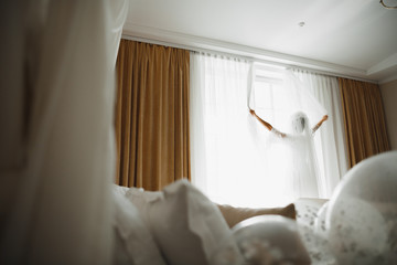 Luxury bride in white dress posing while preparing for the wedding ceremony