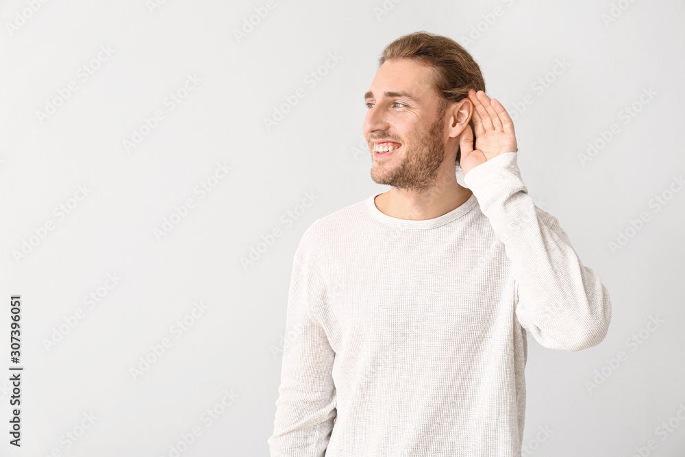 Wall mural young man with hearing problem on white background