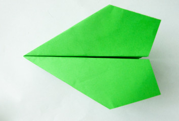 green paper plane on white background.