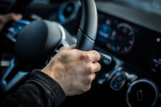 Man's hand holding the steering wheel