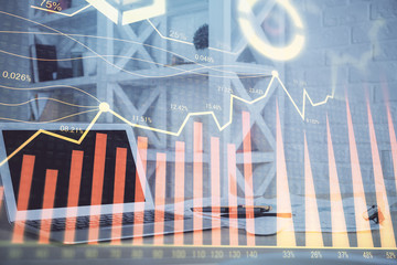 Stock market graph on background with desk and personal computer. Multi exposure. Concept of financial analysis.