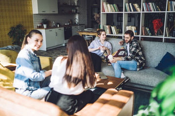 Students communicating sitting in living room