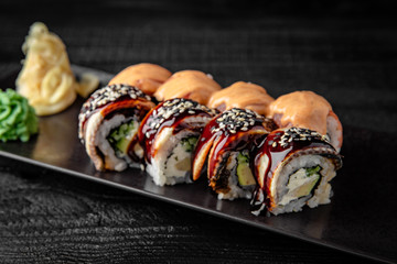 Sushi roll (Maguro) salmon, smoked eel, avocado, philadelphia cheese on black background. Sushi menu. Japanese food.