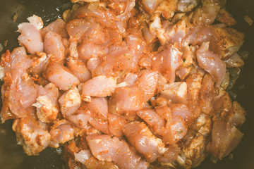 Fresh pieces of raw chicken laid in slow cooker to extinguish.