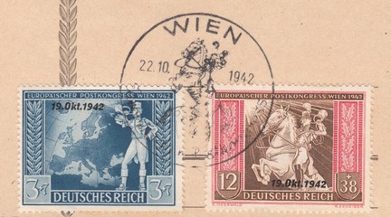 Fototapeta na wymiar Trumpeting postillion in front of map of Europe and Riding postillion. European postal congress of the Axis powers of Vienna,stamp Austria circa 1942