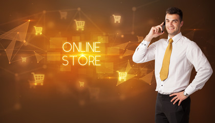 Businessman with shopping cart icons and ONLINE STORE inscription, online shopping concept
