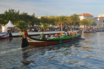 Fototapeta na wymiar Traditional colored boat floats on the water channel Aveiro. Portugal. Summer time