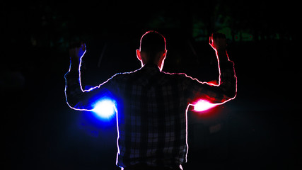 silhouette of  a male  criminal suspect with hands up during night pursuit in front of the police...