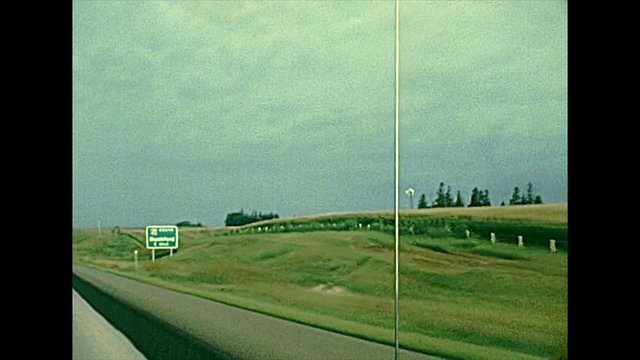 Minnesota State Highway MN 43 to Rushford town in the countryside with local buildings and farms. United States in the 1970s. The historical United States of America.