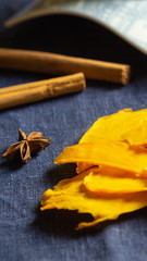 Orange dried mango fruit lie on blue background with a cinnamon