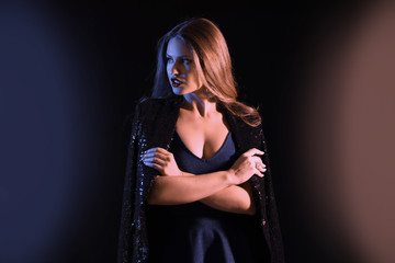 Toned portrait of stylish young woman on dark background