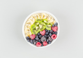 Healthy breakfast smoothie bowl topped with raspberries, blueberries, kiwi, bananas, BlackBerry and seeds chia. Vegan food. 