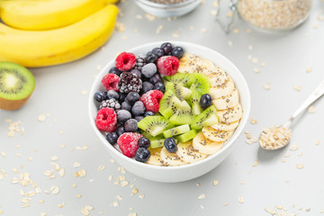 Healthy breakfast smoothie bowl topped with raspberries, blueberries, kiwi, bananas, BlackBerry and seeds chia. Vegan food. 