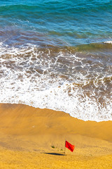 Red flag on the beach during the storm. Atlantic ocean coast, Las Palmas de Gran Canaria island,...