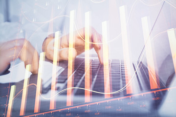 Double exposure of market chart with man working on computer on background. Concept of financial analysis.