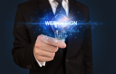 Businessman holding light bulb with WEB DESIGN inscription, innovative technology concept