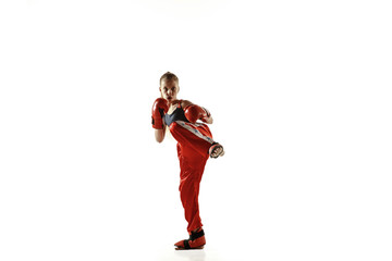 Young female kickboxing fighter training isolated on white background. Caucasian blonde girl in red...