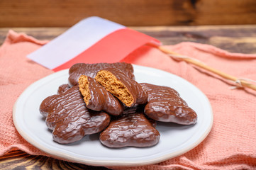 Tasty gingerbread glazed cookies from Torun, Poland and flag of Poland