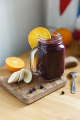 Mason jar mug filled with health smoothie with blackcurrant, blueberry , banana
