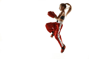 Young female kickboxing fighter training isolated on white background. Caucasian blonde girl in red...