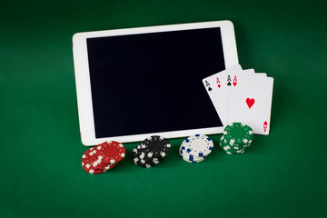 playing chips, four aces and a tablet 