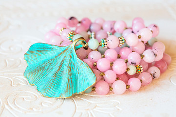 Jewelry mala necklace with natural mineral beads on white wooden decorative background