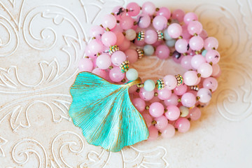 Jewelry mala necklace with natural mineral beads on white wooden decorative background