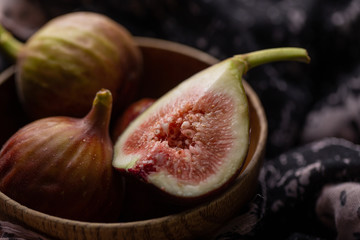 Fresh ripe figs in a bowl closeup on a dark background