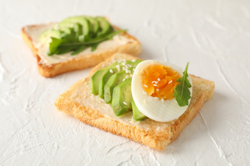 Toasts with avocado and egg on white background, close up