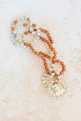 Jewelry mala necklace with natural mineral beads on white wooden decorative background