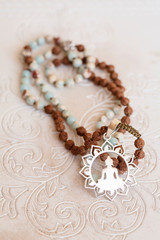 Jewelry mala necklace with natural mineral beads on white wooden decorative background