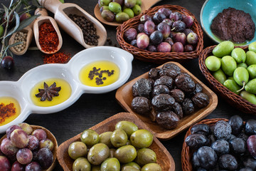 Many types of olive like green & black and olive oil at the black background