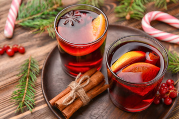 Glasses of tasty mulled wine on wooden background